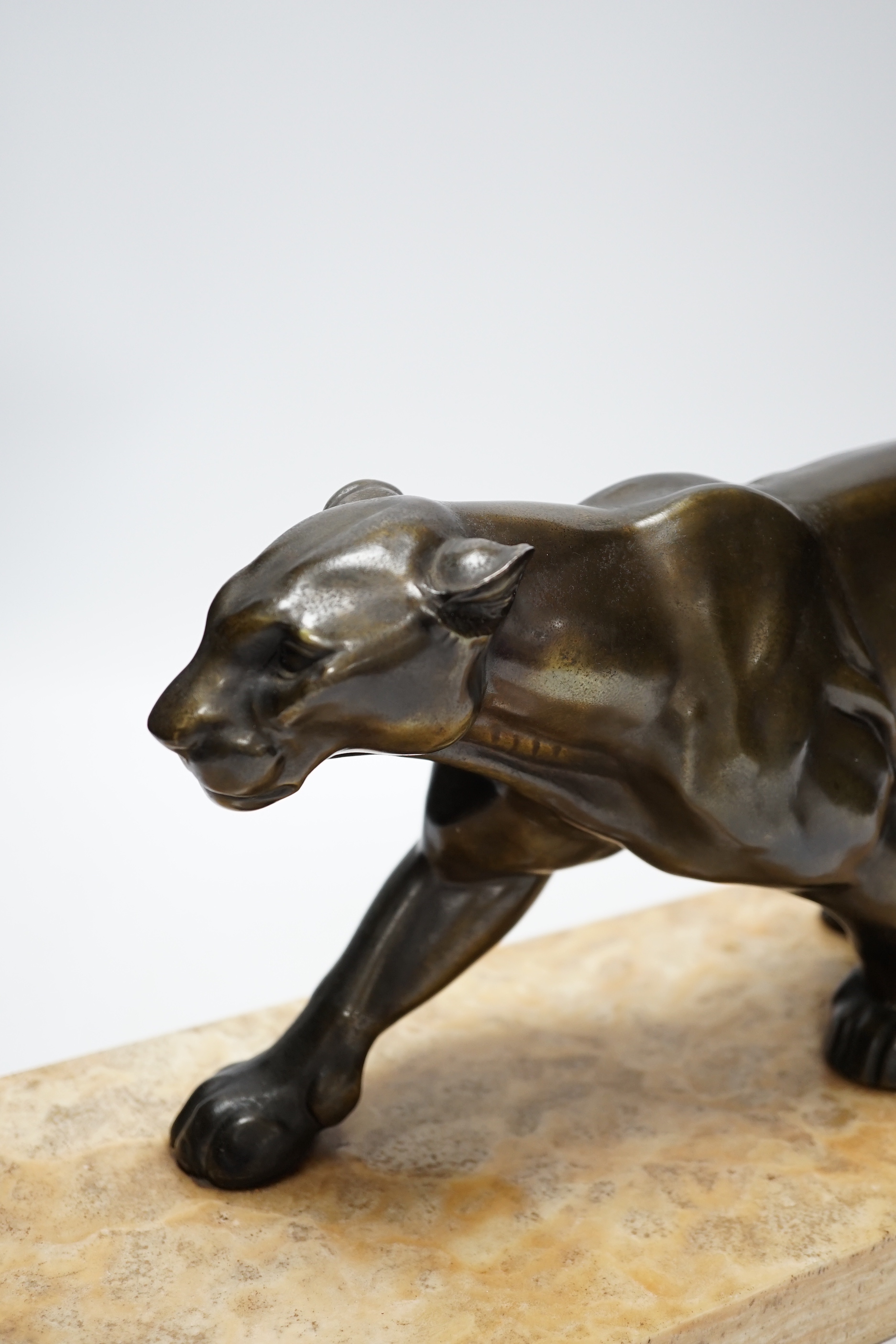 A French Art Deco bronzed metal model of a panther on a marble base, base 55cm wide